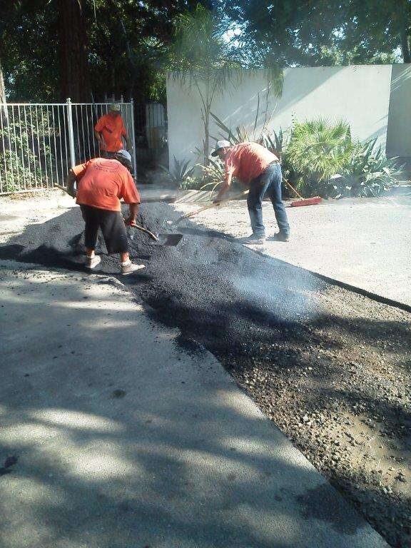 Crew raking hot mix into a repair.